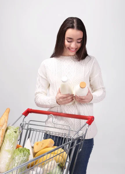 Jeune femme avec poussoir plein shopping — Photo