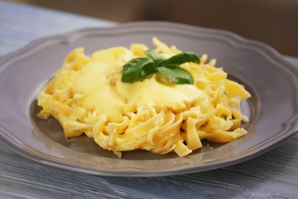 Bord met heerlijke pasta en kaassaus — Stockfoto