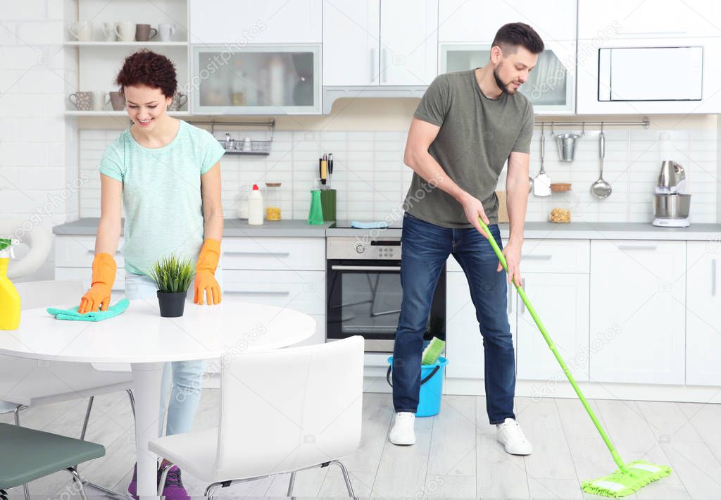young couple cleaning kitchen 