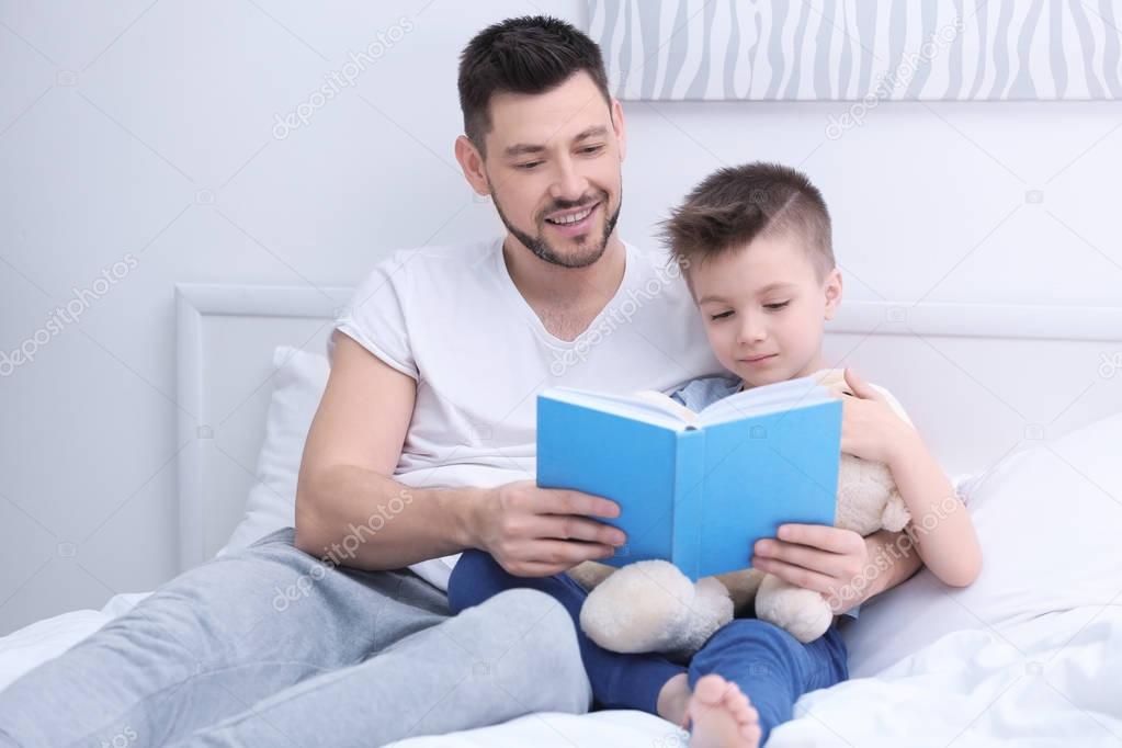 Dad and son reading interesting book 