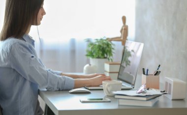 Evde dizüstü bilgisayarda çalışan bir kadın.