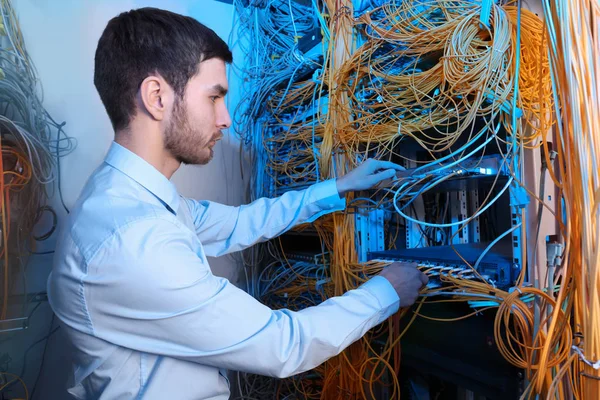 Ingeniero joven guapo trabajando en la sala de servidores — Foto de Stock