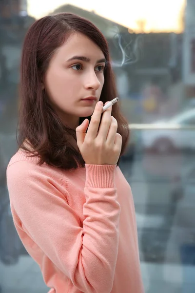 Adolescente chica fumar en ventana fondo — Foto de Stock