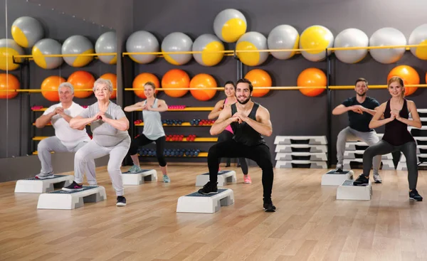 Les gens de différents âges s'entraînent dans la salle de gym — Photo