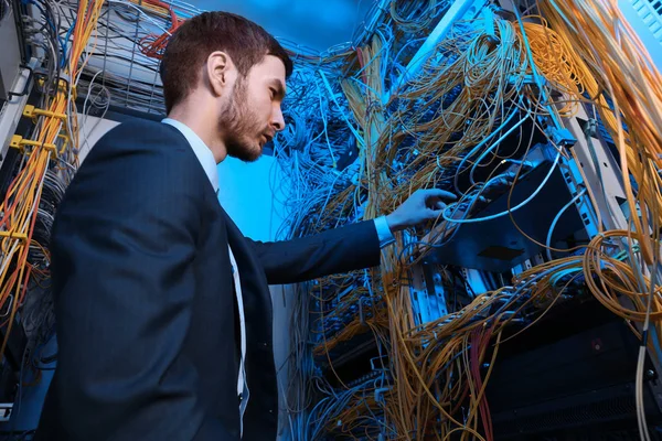 Ingeniero joven guapo trabajando en la sala de servidores — Foto de Stock