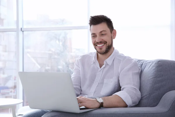 Bello giovane uomo con computer portatile — Foto Stock