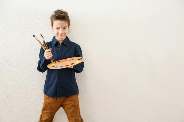 Lindo pequeño artista cerca de pared de luz — Foto de Stock