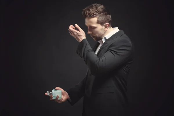 Handsome young man using perfume — Stock Photo, Image