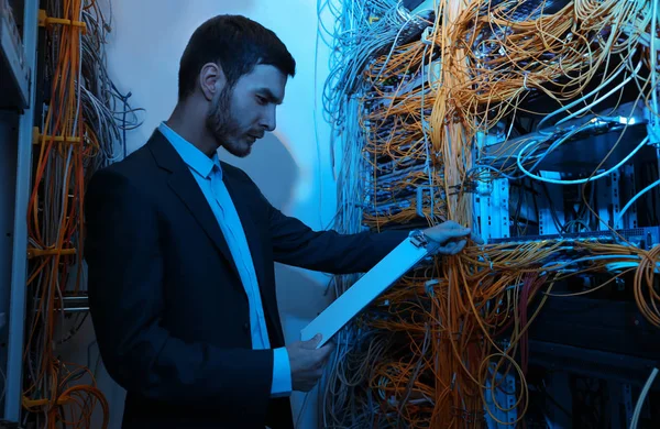 Ingeniero joven guapo trabajando en la sala de servidores —  Fotos de Stock