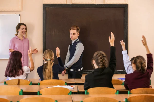 Ученики Слушают Учителя Поднимают Руки Ответить Классе — стоковое фото