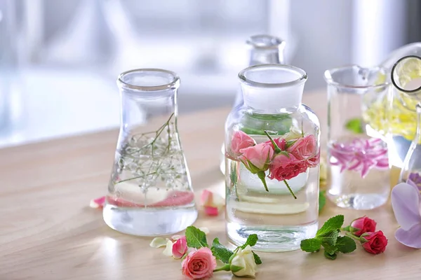 Schöne Komposition mit Parfümmustern und Blumen auf dem Tisch — Stockfoto