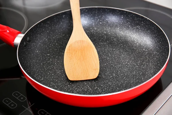 Wooden spatula in frying pan — Stock Photo, Image