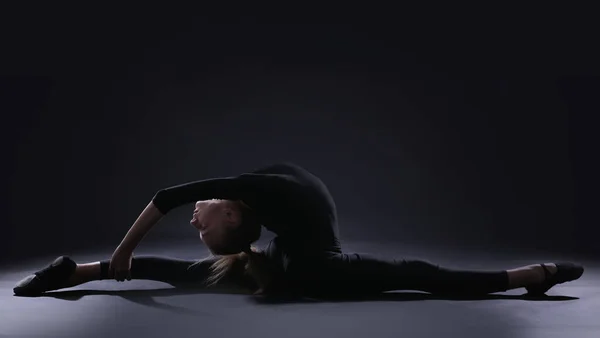 Chica joven haciendo gimnasia sobre fondo oscuro —  Fotos de Stock