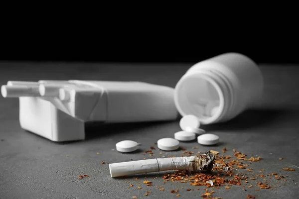 Damaged cigarette, pack and pills — Stock Photo, Image