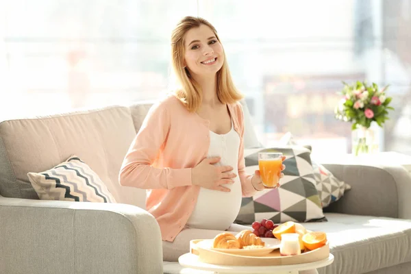 Молодая беременная женщина завтракает — стоковое фото