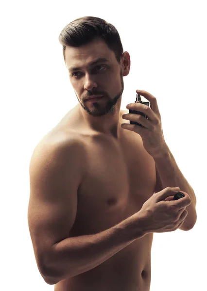 Handsome young man using perfume — Stock Photo, Image