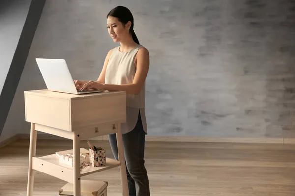 Asiatin tippt auf Laptop — Stockfoto