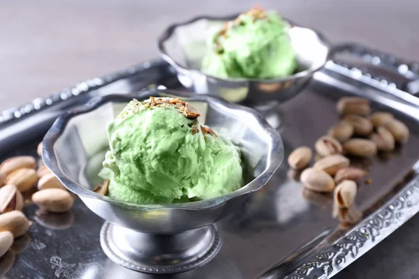 Dessert bowls with delicious pistachio ice cream on metal tray — Stock Photo, Image