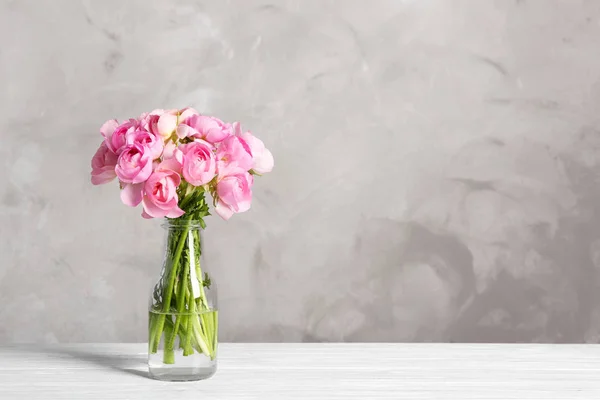 Vase with beautiful bouquet of ranunculus flowers on table — Stock Photo, Image