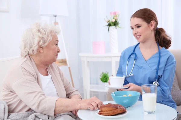 Mujer mayor desayunando en la sala de luz — Foto de Stock