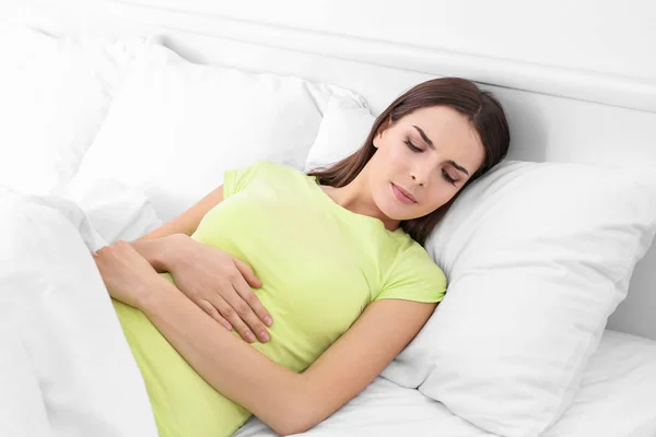 Ung sjuk kvinna ligger i sängen hemma — Stockfoto