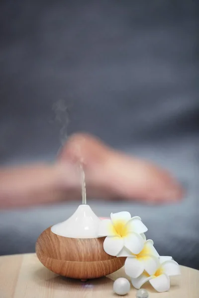 Concetto Spa. diffusore olio aromatico sul tavolo contro sfondo sfocato — Foto Stock