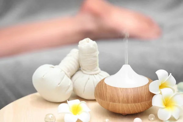 Wellness-Konzept. Aromaöldiffusor auf Tisch vor verschwommenem Hintergrund — Stockfoto