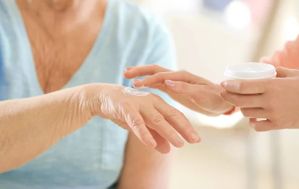 Mujer aplicando crema en la mano —  Fotos de Stock