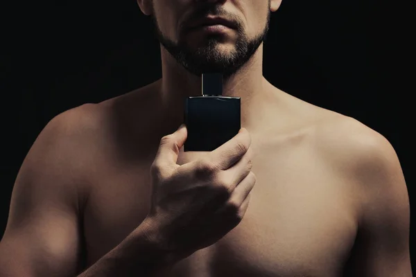 Snygg ung man som använder parfym — Stockfoto
