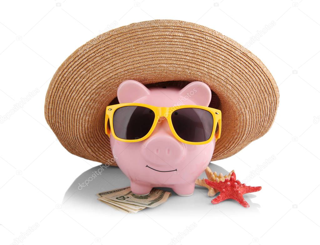 Vacation budget concept. Piggy bank in straw hat with sunglasses and money on white background