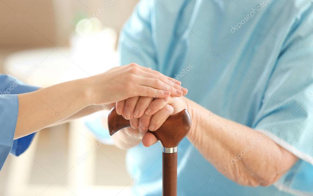 doctor holding hands of elderly woman