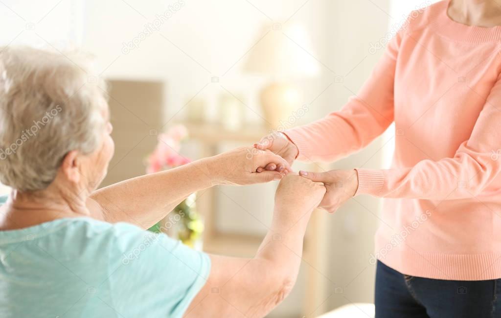 Old and young women holding hands 