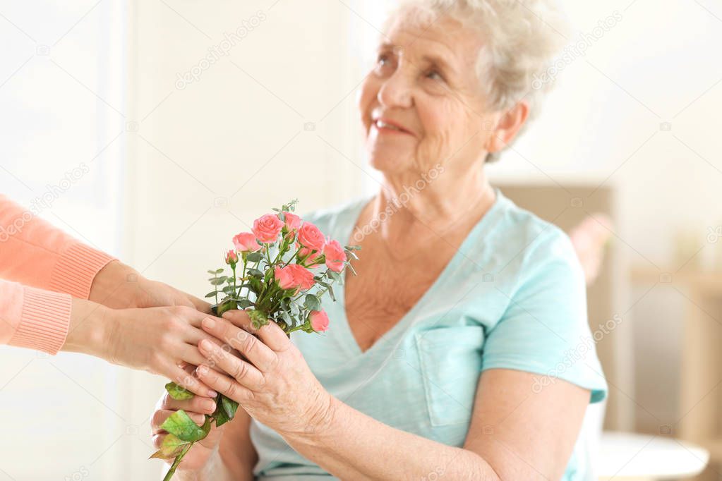 giving flowers to old woman