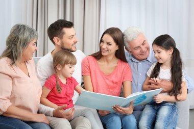 Kitap odasında kanepede oturan ile mutlu aile