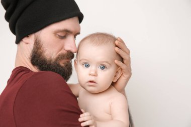 Şirin Bebek ışık arka plan üzerinde tutarak dövmeli yakışıklı genç