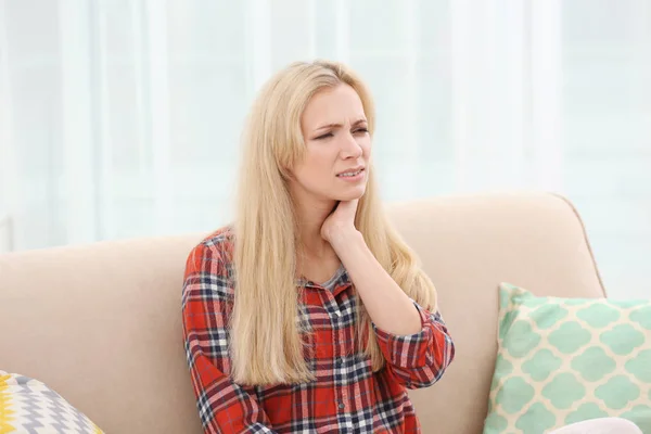 Молода жінка з алергією сидить на дивані вдома — стокове фото