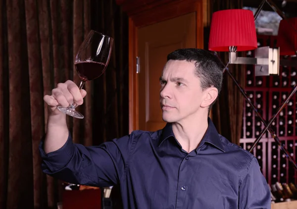 Elinde kırmızı şarap kadehi tutan yakışıklı adam. — Stok fotoğraf
