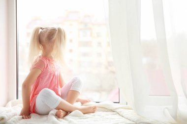 girl sitting on windowsill