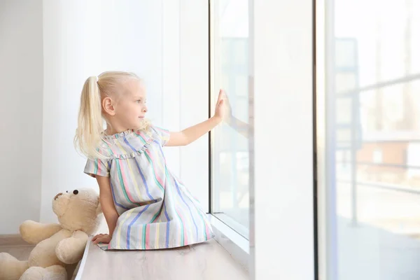 Girl sitting on windowsill — Stock Photo, Image