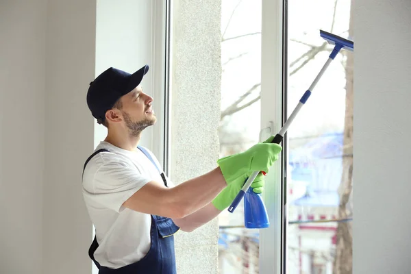 Jeune homme lavage de fenêtre — Photo