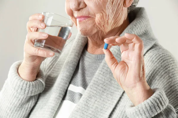 Mujer de edad avanzada tomando píldora —  Fotos de Stock