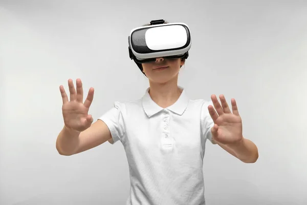Retrato de niña divirtiéndose con auriculares de realidad virtual sobre fondo claro — Foto de Stock