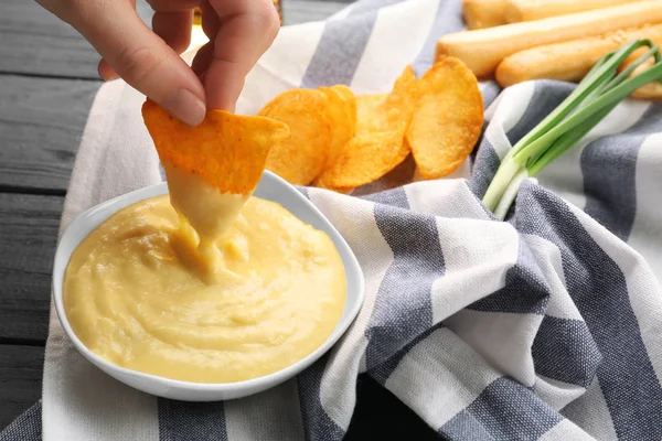 Vrouw hand dompelen nacho — Stockfoto