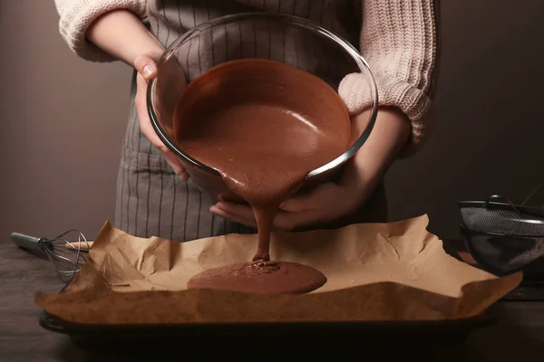 Woman pouring cocoa liquid dough — Stock Photo, Image