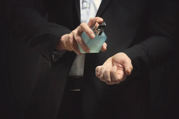 Handsome young man using perfume — Stock Photo, Image