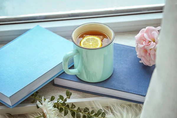 Cup of tea and books on windowsill