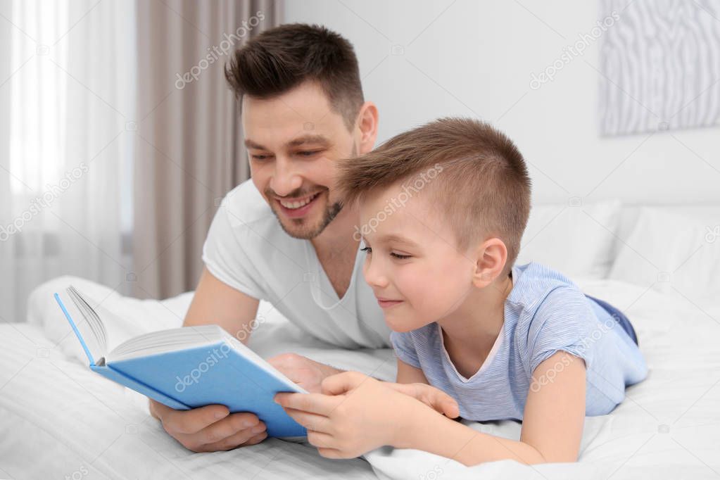 Dad and son reading interesting book  