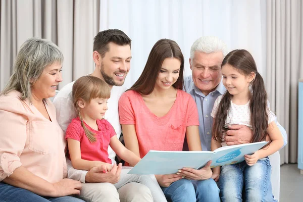 Gelukkige Familie Met Boek Zittend Bank Kamer — Stockfoto