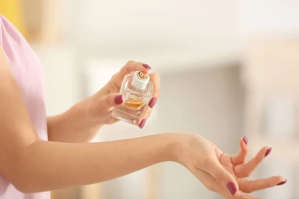 Jeune femme avec bouteille de parfum — Photo