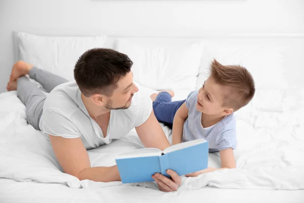 Pappa och son läser intressanta bok — Stockfoto